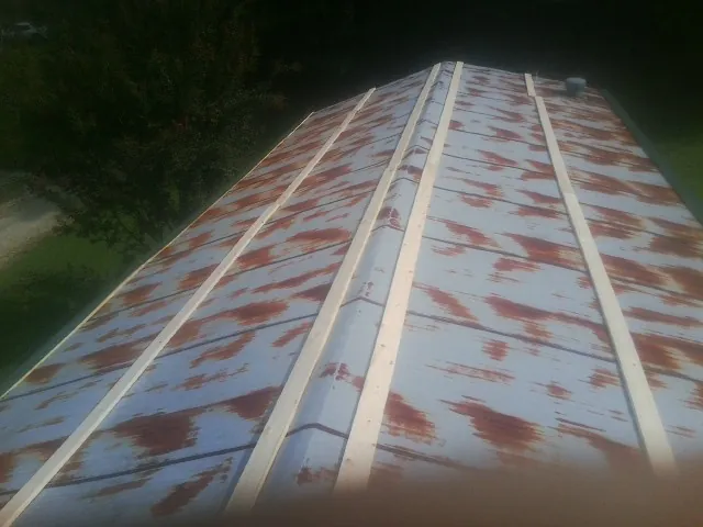 Rusted metal roof panels with new wood purlins before replacement — Storm Damage Roof Repair in Arnold by Roofing Brothers