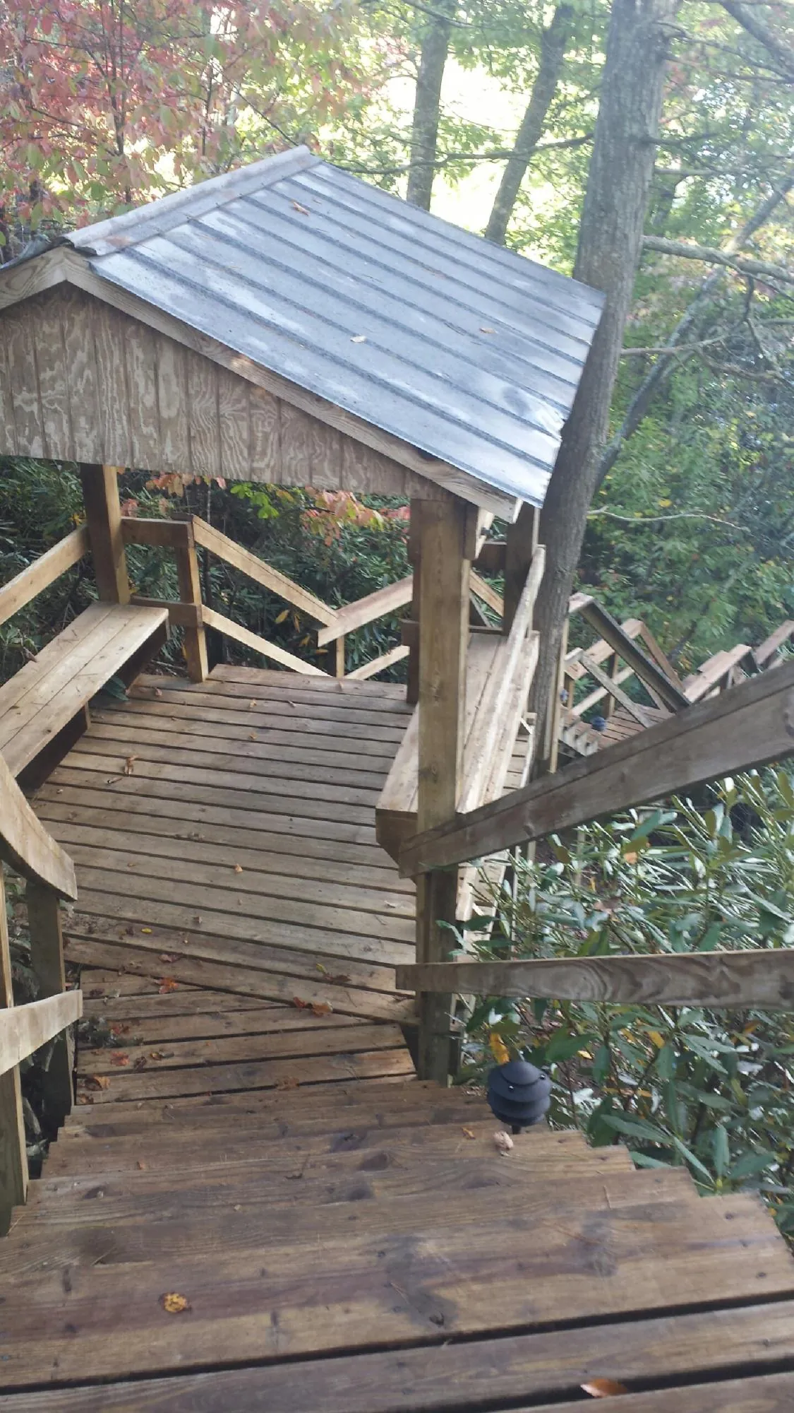 Metal roofed shelter over wooden steps on a wooded walkway — Skylight Repair & Installation work by our crew in Arnold