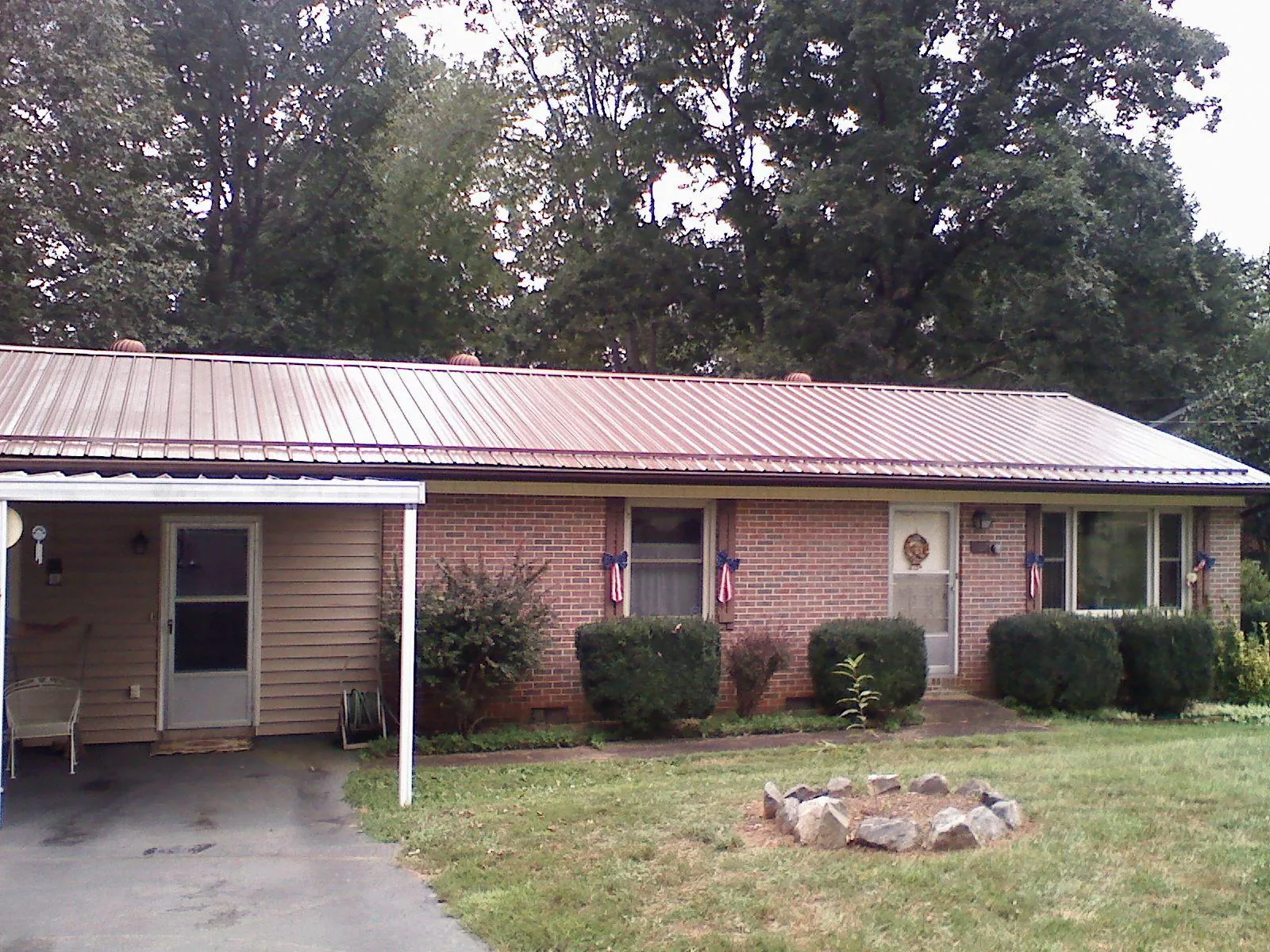 Bronze metal roof and carport on a brick ranch home — Roof Repair work by our crew in Arnold